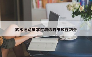 武术运动员拿过教练的书放在剑旁